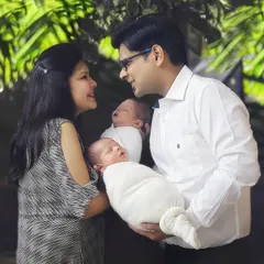 Twice the smiles, twice the love. A beautiful candid moment between new parents as they gaze lovingly at each other while holding their precious newborn twins.
