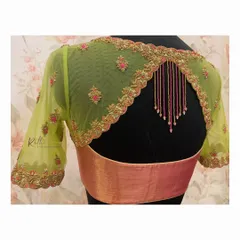 A unique back design on a lime green net blouse. The scalloped cutwork is highlighted with pink and gold embroidery, and beaded tassels add a playful touch.
