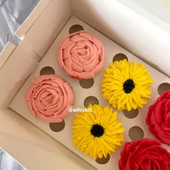 These handcrafted floral cupcakes are too pretty to eat. Featuring red roses, sunflowers, and pink peonies, they are a work of edible art perfect for a bridal shower or engagement party dessert table.
