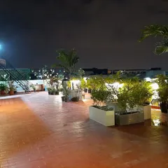A 1500 sqft commercial terrace garden I designed on Kanakpura Road, pictured at night. The layout uses large planters to define the space and incorporates strategic garden lighting to create a warm and inviting ambiance for evening use.