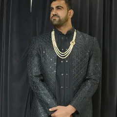 Our "desi look" featuring a textured black Indo-western jacket over a matching kurta, elevated with a multi-strand pearl mala. This is a client favorite for its sharp and royal feel.