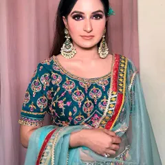 A full portrait showcasing the complete look. The teal and multi-color outfit is vibrant and fun, and the bold eye makeup is the perfect choice to match its energy.
