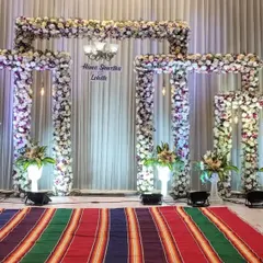 We can adapt our stage designs to match different cultural traditions. Here, the same floral frame stage from the featured section is customized with a traditional striped 'jamkhana' rug for a classic touch.