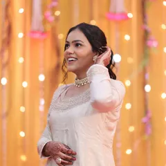 A candid, happy shot of a bridesmaid. Her makeup is soft and fresh, with a simple ponytail hairstyle that is both elegant and comfortable for a long day of celebrations.