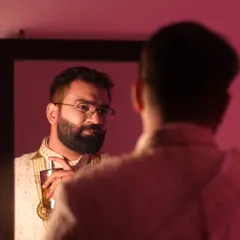 A reflective moment for the groom, captured in a mirror. This artistic shot offers a glimpse into his thoughts on the big day.
