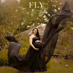 A dramatic shot with a flowing black gown. The makeup is elegant and understated, ensuring the focus remains on the beautiful mom-to-be.