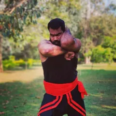 A demonstration of a powerful blocking technique from the Kalaripayattu system. This pose shows the immense upper body strength and control required to master this ancient martial art.