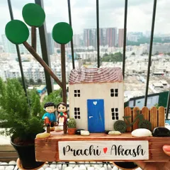 Set against a city skyline, this nameplate captures the feeling of finding your peaceful haven. The design features a couple on a bench, a tiny bicycle, and lush trees, all handcrafted from wood.