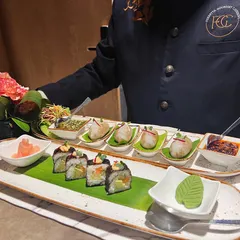A platter of assorted Asian appetizers, including delicate dim sum and fresh sushi rolls. This demonstrates the breadth of our international cuisine offerings, perfect for sophisticated palates.