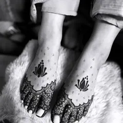A minimalist and elegant feet mehandi design. This black and white photo highlights the simple yet beautiful lotus motifs, perfect for a modern bride.