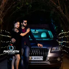 For a sleek and modern pre-wedding shoot, we can incorporate a luxury car like this Audi. The dark, moody lighting and the couple's confident pose create a powerful and stylish image.