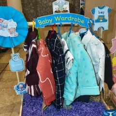 The 'Baby Wardrobe' for the twin baby boy, with a collection of smart and casual outfits arranged on a rack.