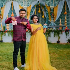 An outdoor maternity shoot celebrating the upcoming arrival. This couple wanted to announce their joy with cute props like baby shoes and their ultrasound picture, set against a beautiful event backdrop.