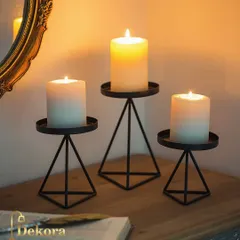 This set of three black metal candle stands features a modern geometric pyramid base. Their minimalist design is perfect for contemporary corporate settings or as a stylish housewarming gift.