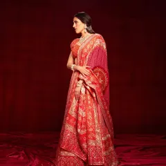 A classic red and gold bandhani lehenga by Abu Jani Sandeep Khosla. This is a timeless bridal look, featuring exquisite craftsmanship that feels both traditional and incredibly luxurious.