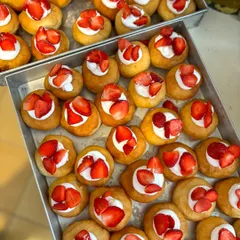 Trays of fresh strawberry and cream bombolinis getting ready for a birthday celebration.