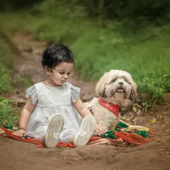 There is a special magic when a child and their furry friend share a quiet moment. This outdoor portrait captures the gentle, unspoken bond between a little girl and her dog on a rustic forest path.