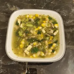 This is a perfect example of a hearty, vegetarian soup packed with nutrients. It's filled with broccoli, corn, mushrooms, and tofu, making it a complete and satisfying meal. Eating a plant-based diet can be a delicious and vibrant lifestyle.