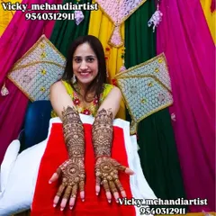 A beautiful, happy bride posing with her intricate full-arm mehndi against a festive backdrop.