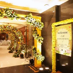 The welcome signage and entrance decor for the Haldi, combining traditional marigold garlands with modern floral arrangements and a custom-designed welcome board.