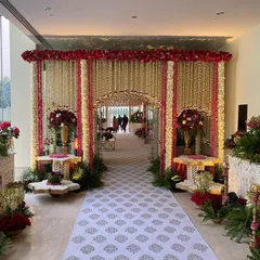 A breathtaking entrance for a traditional wedding ceremony, adorned with thousands of fragrant white mogra and deep red flowers. This grand floral archway sets a tone of reverence and opulence for the sacred event.