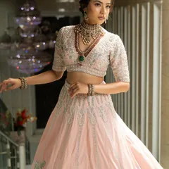 Twirl into a fairytale with this baby pink bridal lehenga. I designed it with intricate horse embroidery on the raw silk skirt and paired it with a heavily handworked blouse and a delicate net dupatta for a truly heavenly look.