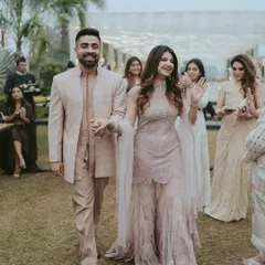 The couple's happy entrance into their Roka ceremony. This candid shot captures their excitement as they walk hand-in-hand, greeted by their loved ones.