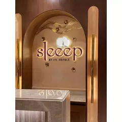 The illuminated brand signage for "Sleeep by ITC Hotels" set within a custom arched niche. The warm backlighting and intricate details reflect the high standards of this luxury hospitality brand.