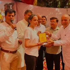 Another student being honored on stage for her dedication to the practice of yoga.