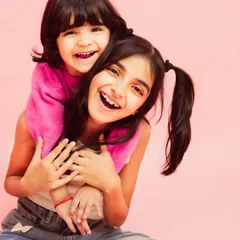 The pure, unfiltered joy of sisterhood. This studio kids photoshoot was all about capturing their vibrant energy and laughter against a simple, bright pink backdrop that lets their personalities shine.