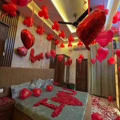 To make your partner feel incredibly special, I can transform your bedroom into a romantic haven. This decoration features hundreds of red balloons, heart-shaped foil balloons, and a bed covered in rose petals spelling out 'I love you'.