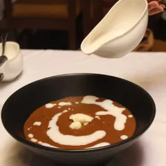The final touch on our classic Dal Makhani. A swirl of fresh cream is added to the slow-cooked black lentils, giving it a rich, buttery finish that is simply irresistible.