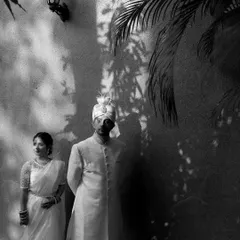 A classic black and white portrait using shadows and light for a dramatic effect. This shot feels timeless and artistic, capturing the couple in a moment of quiet elegance.
