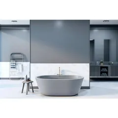 A minimalist bathroom with a freestanding grey bathtub as the centerpiece. The half-wall of white marble tiles and the simple, clean lines create a serene and contemporary look.