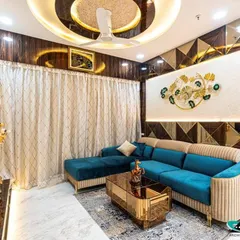 Another angle of the stunning Lodha Belair living room, highlighting the intricate geometric patterns on the wall and the custom-fluted sofa design. The gold coffee table adds a touch of opulence to the space.