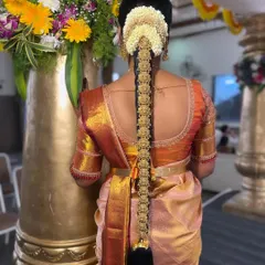 The beauty of a South Indian bride is in the details. This is a close-up of a traditional bridal hairstyle, featuring an intricate Jadde Bangara (hair jewellery) set against a classic braid and fresh jasmine flowers. I ensure every element, from the hair to the flowers, is perfectly placed and secure for the entire ceremony.