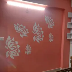 A beautiful arrangement of white lotus flower stencils on a calming coral-pink wall, creating a serene and decorative floral feature.