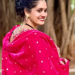 A radiant smile from a client looking over her shoulder. This highlights the beautiful hairstyle and jewelry that completes the traditional Maharashtrian look.