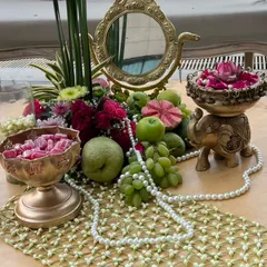 A close-up of a 'Bagh-e-Ishq' themed tablescape, blending fresh fruits, delicate flowers, pearls, and traditional brass decor. Our traditional event designs are rich with poetic details and cultural heritage.