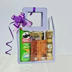 A budget-friendly and fun hamper for Rakshabandhan. This clear bag is filled with Pringles, hot chocolate mix, and Ferrero Rochers, making it a perfect treat for your brother or sister.