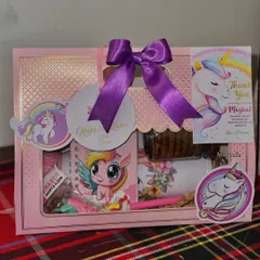 A closer look at the Unicorn-themed version of our kids' hamper. This one features a cute notebook, pen, eraser, and other treats, all tied together with a lovely purple bow.