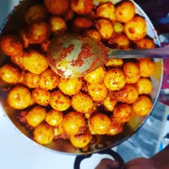 A top view of the Amla pickle being mixed in a kadai. This traditional method helps infuse the flavors deeply into the amla.