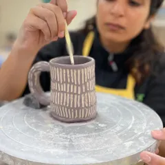 This student is using the sgraffito technique, painting a layer of color and then carving through it to reveal the clay body underneath.