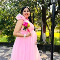 This mom-to-be is glowing in her outdoor pregnancy photoshoot. The park setting provides a simple yet beautiful backdrop for her pink gown.
