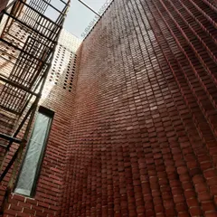 Our expertise in material craftsmanship is demonstrated in this double-height brick wall. The unique, undulating pattern interacts with natural light from the skylight above, creating a textured, warm surface that transforms a simple wall into a piece of architectural art.