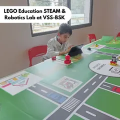 A student at our LEGO Education STEAM & Robotics Lab at Vidyashilp School, Banashankari (VSS-BSK), uses a tablet to program his creation on the city-themed mat, learning coding through playful storytelling.