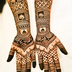 This engagement mehendi features symbolic motifs. A prominent lotus and a traditional dome are incorporated into the design on both hands, surrounded by intricate lattice work and bold, dark fingertips.