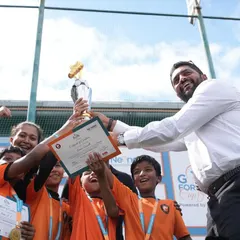 Victory! Our technical director, Adhip Bhandary, presents the championship trophy to a winning team at the Goal for the Good Cup. We love celebrating success and sportsmanship.