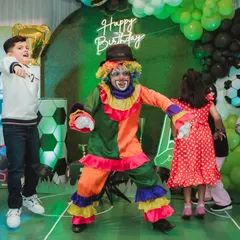 A colorful clown dances with the kids at a football-themed birthday party. My entertainers are experts at getting everyone involved and keeping the energy high.