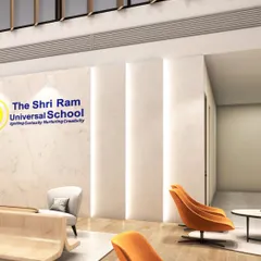 A detail shot of the lobby, where the school's identity is seamlessly integrated into the marble wall. The use of recessed vertical lighting adds depth and elegance, while the carefully chosen furniture provides comfort for visitors.